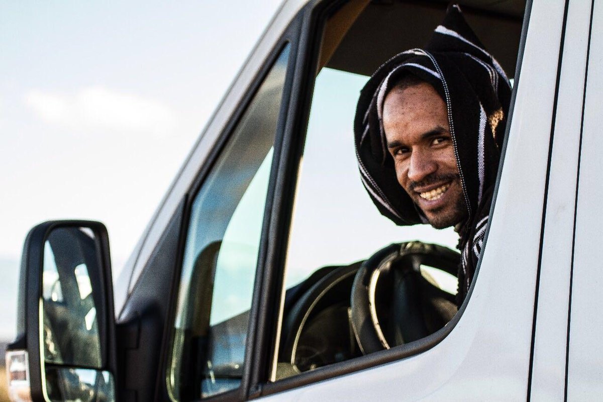 Aziz, founder of Connecting Destinations, smiling from his vehicle